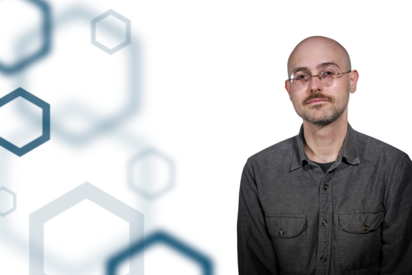 Dr. Daniel Spencer on the right with a white background and navy hexagon shapes on the left. 